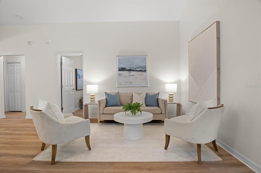 A living room features a beige sofa, two armchairs, a round coffee table, and artwork — 4019 CARTERET DRIVE, WINTER HAVEN, FL
