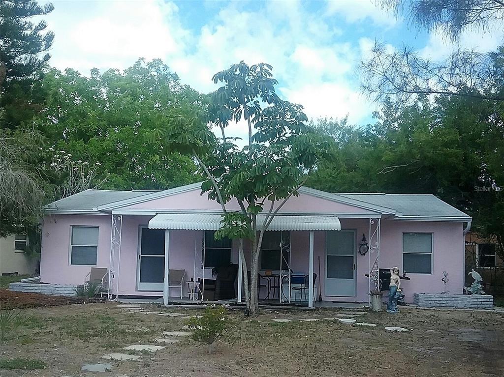 A single-story pink house with a covered front porch and a central tree in front — 586 140TH AVENUE E UNIT 2, MADEIRA BEACH, FL
