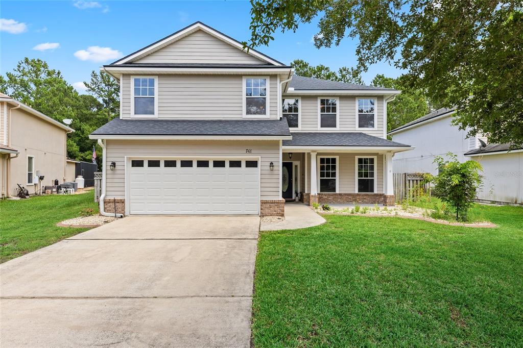 A backyard with a screened-in patio, a small tree, and a black metal fence — 741 FLOWERS STREET, ST AUGUSTINE, FL