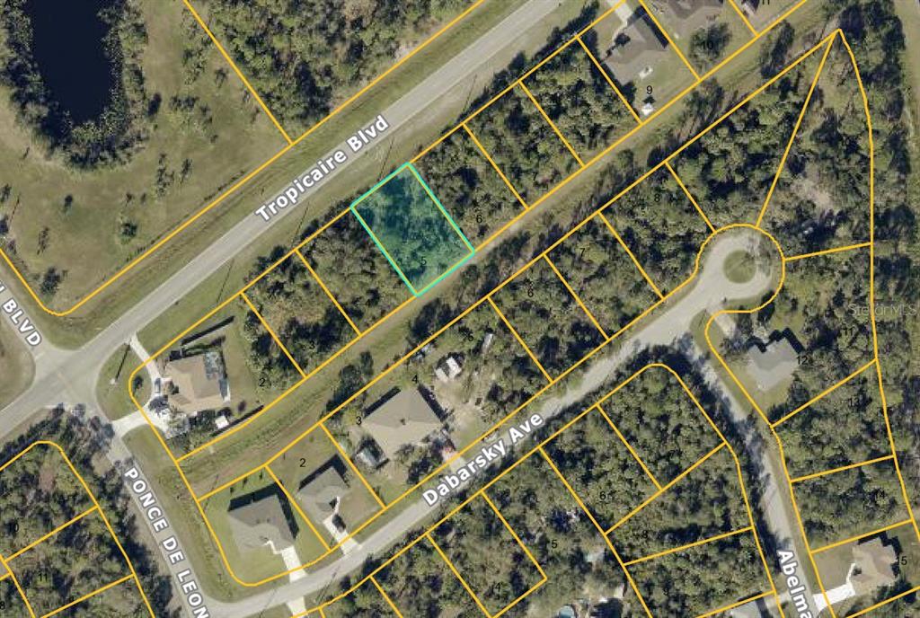 This is an aerial map view of a residential lot highlighted in blue — TROPICAIRE BOULEVARD, NORTH PORT, FL