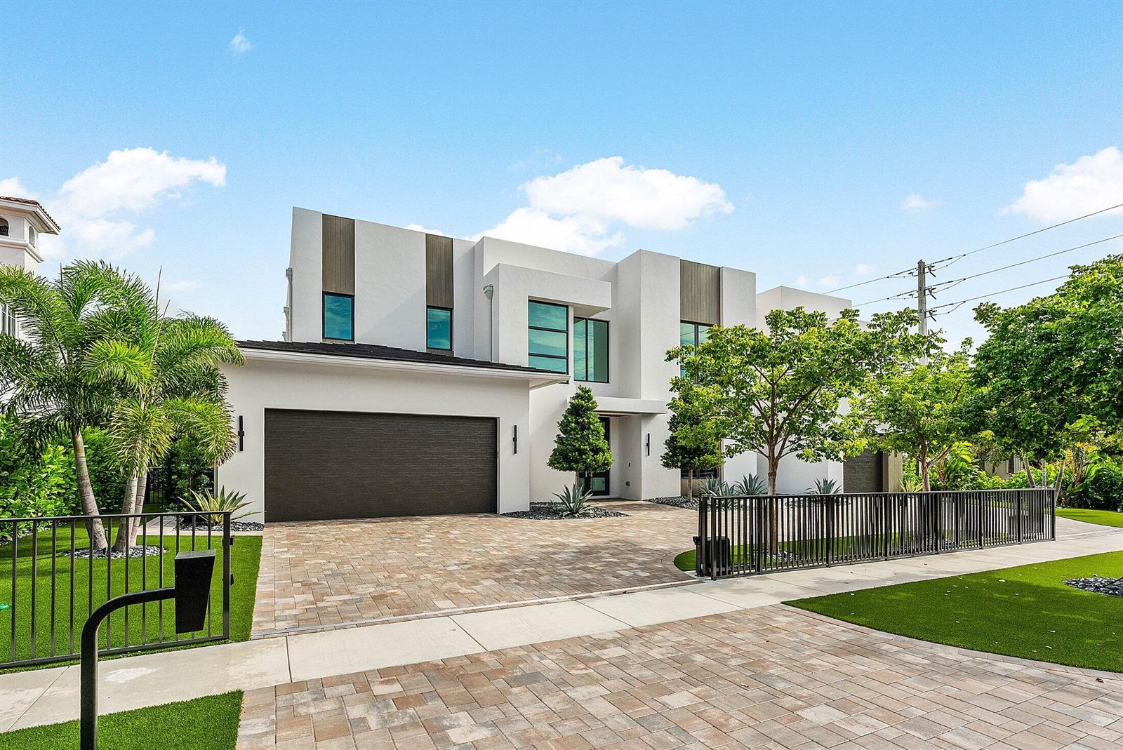 A modern two-story house with a white facade, dark garage door, and paved driveway — 499 NE 4th Street, Boca Raton FL 33432, BOCA RATON, FL