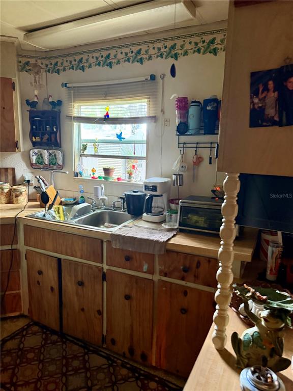 A kitchen features wood cabinets, a stainless steel sink, and a window above the counter — 11710 NE 222ND LANE, FORT MC COY, FL