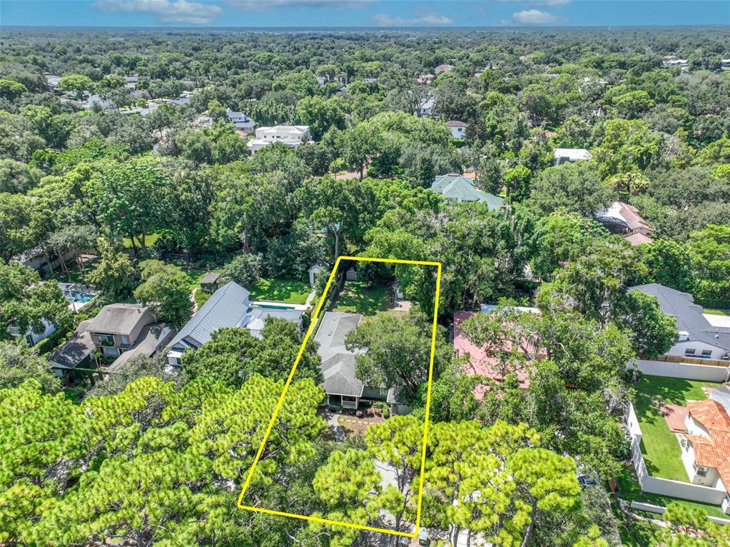 An aerial view shows a single-story house surrounded by dense trees within a yellow boundary — 150 E READING WAY, WINTER PARK, FL