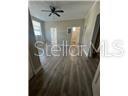 A room with wood-look flooring, a ceiling fan, and a doorway leading to another area — 2702 N FLORIDA AVENUE UNIT 6, TAMPA, FL