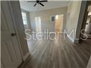 A room with light wood-look flooring, a ceiling fan, and two doorways — 2702 N FLORIDA AVENUE UNIT 6, TAMPA, FL