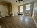 An empty room with light wood-look flooring, two windows, and a ceiling fan — 2702 N FLORIDA AVENUE UNIT 6, TAMPA, FL