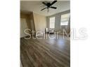 An empty room with wood-look flooring, a ceiling fan, and large windows — 2702 N FLORIDA AVENUE UNIT 6, TAMPA, FL