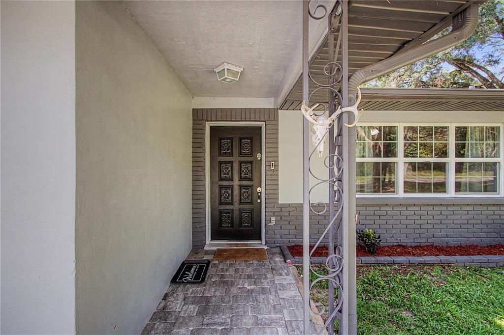 A front entrance features a dark paneled door, a brick facade, and a decorative metal post — 20260 SW 80TH PLACE ROAD, DUNNELLON, FL