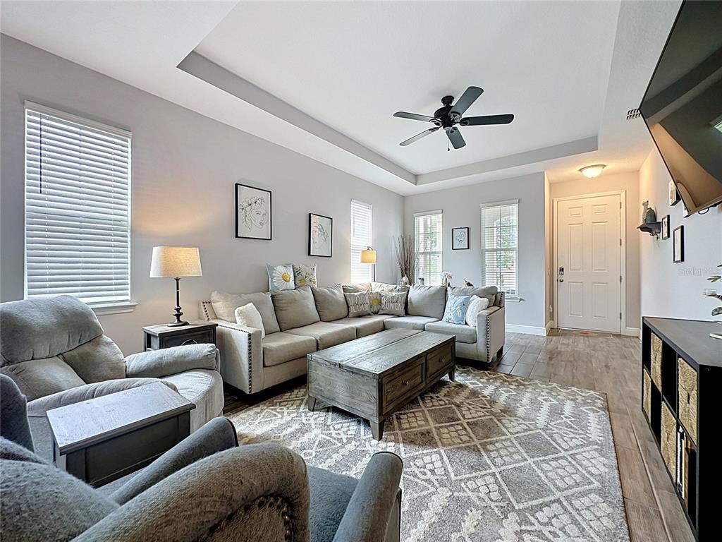 A living room features a sectional sofa, a coffee table, and a tray ceiling — 105 ABERDEEN STREET, DAVENPORT, FL