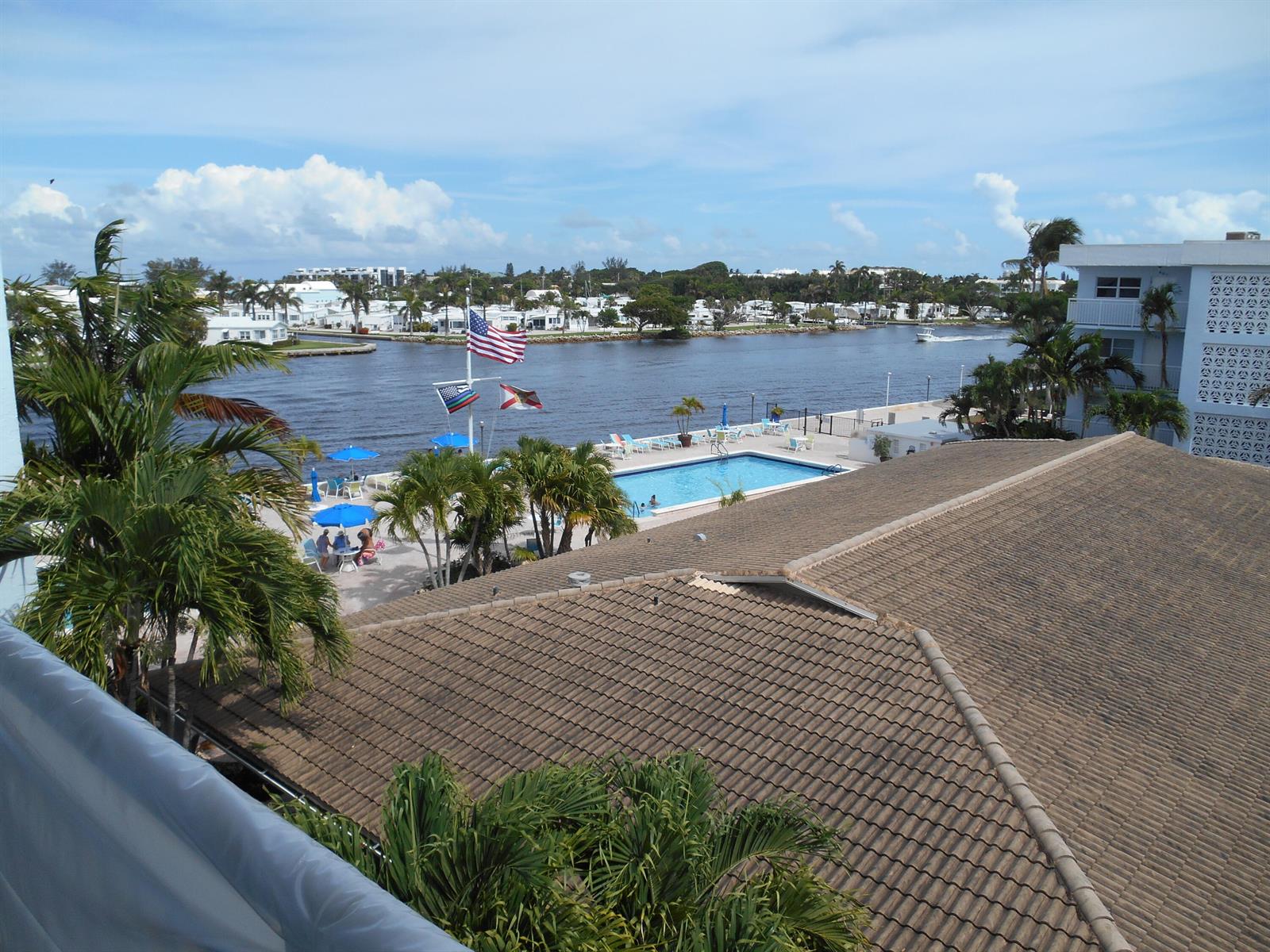An elevated view shows a swimming pool, palm trees, and a waterway with boats — 2016 S Federal Highway # 204, Boynton Beach FL 33435, BOYNTON BEACH, FL
