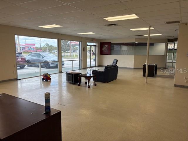 An open commercial office space with large windows, a dark armchair, and light flooring — 6464 E COLONIAL DRIVE, ORLANDO, FL