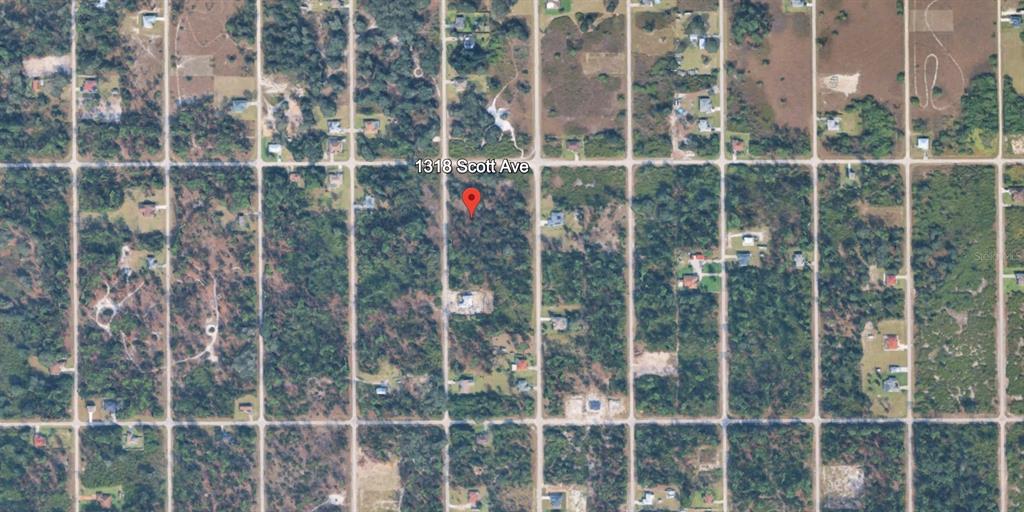 This aerial map view shows a vacant, wooded residential lot located along a grid-patterned road — 1318 SCOTT AVENUE, LEHIGH ACRES, FL