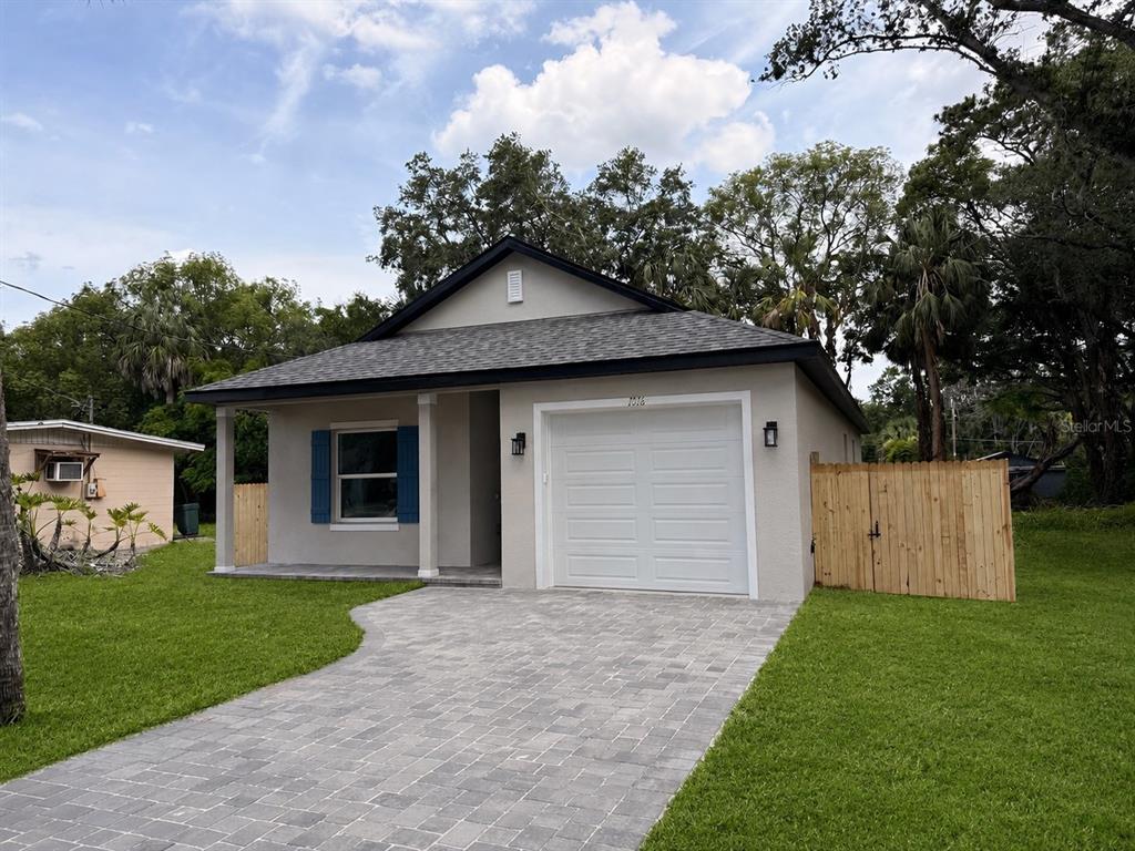 A single-story house with a gray exterior, a white garage door, and a paved driveway — 1816 W 16TH STREET, SANFORD, FL
