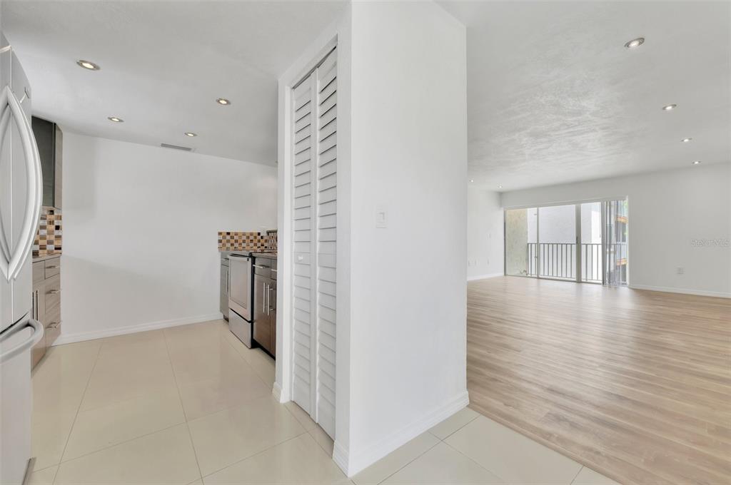 A kitchen with tile floors and a living area with wood floors and a balcony — 592 100TH AVENUE N UNIT 201, ST PETERSBURG, FL