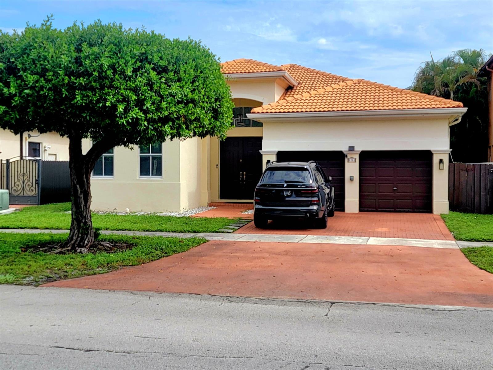 A single-story house with a terracotta tile roof, a two-car garage, and a black SUV — 8781 NW 178th Street, Hialeah FL 33018, HIALEAH, FL