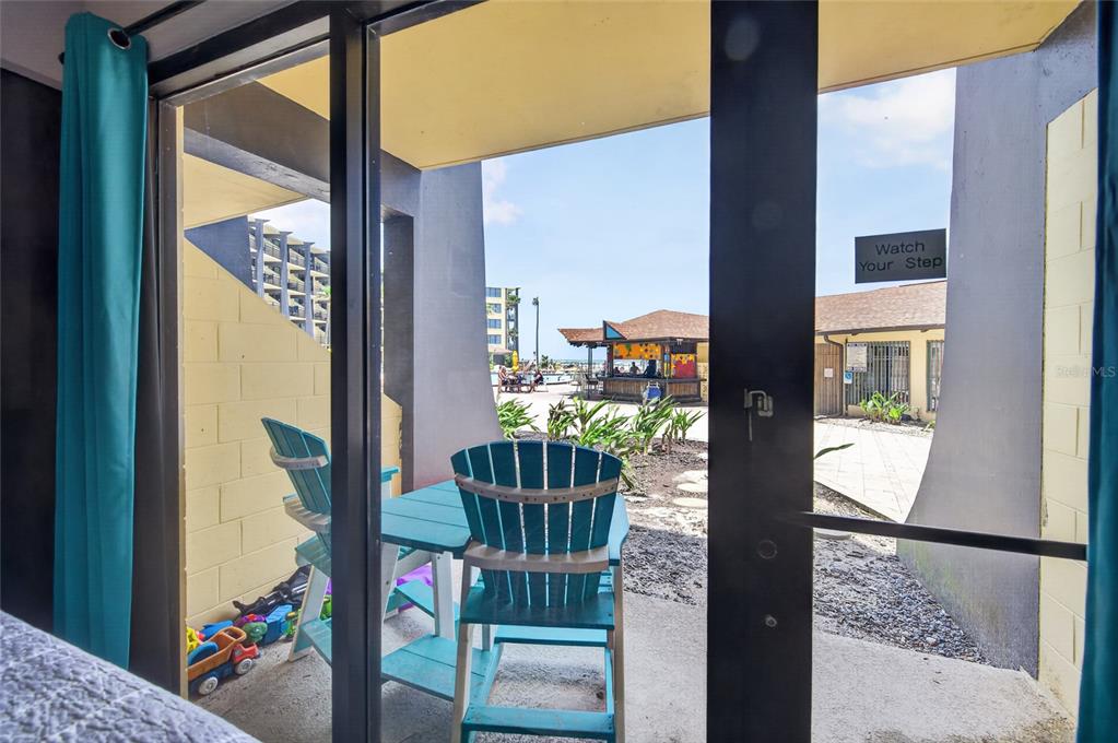 A view from inside a room looking out through sliding glass doors to a patio — 2301 S ATLANTIC AVENUE UNIT 127, DAYTONA BEACH, FL