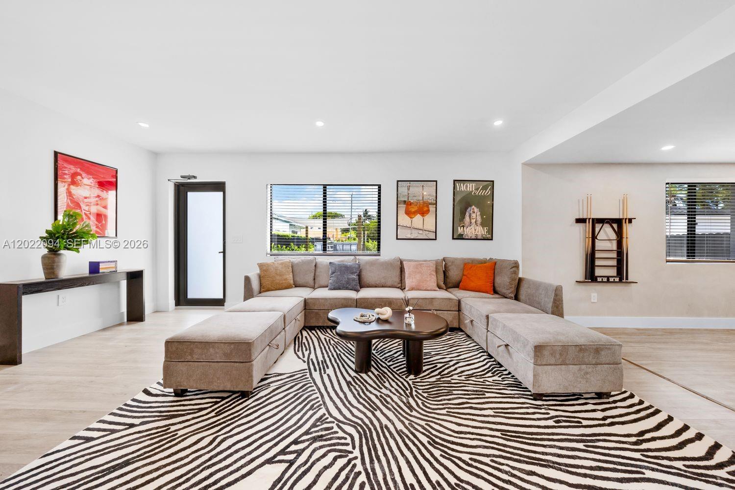 A living room features a large sectional sofa, a zebra-print rug, and a coffee table — 111 NW 53rd St, Miami FL 33127, MIAMI, FL