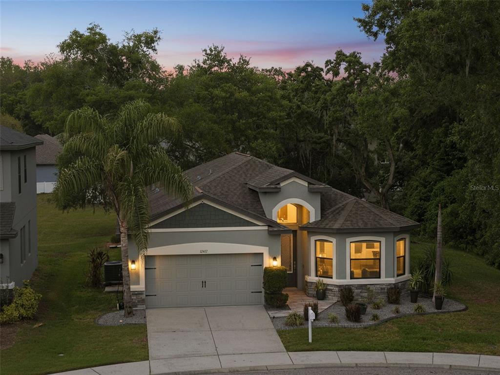 An aerial view of a single-story house with a gray exterior, stone accents, and garage — 12417 CORALBEAN COURT, NEW PORT RICHEY, FL
