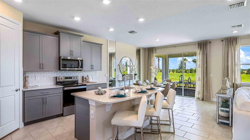 A dining area features a round wooden table, woven chairs, and a sliding glass door — 4306 SILVER BIRCH COURT, PALMETTO, FL