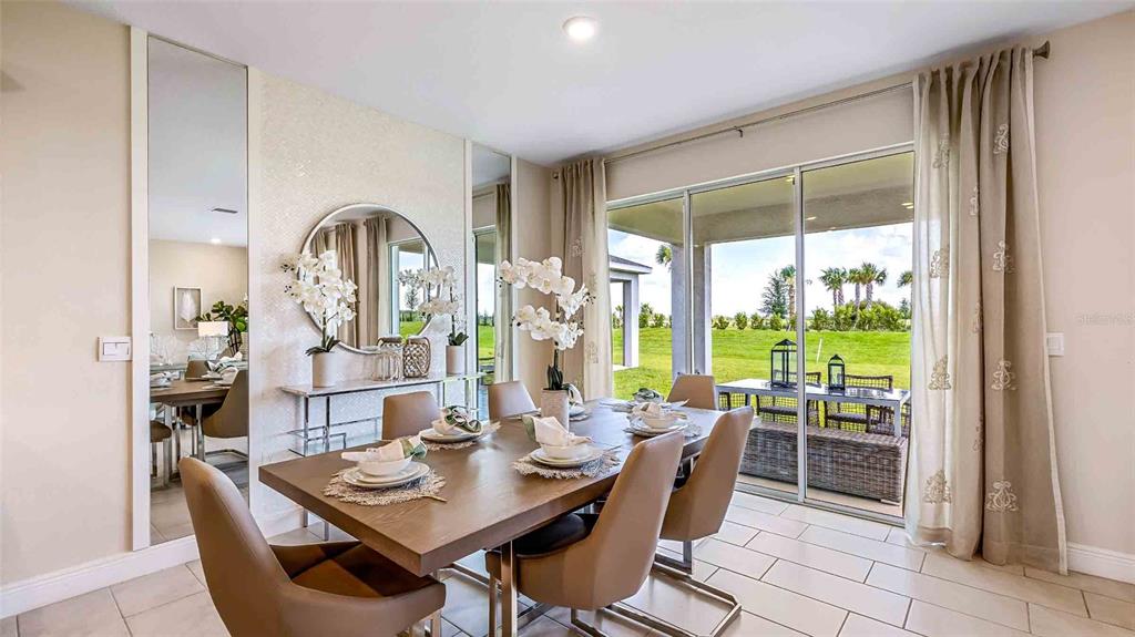 A kitchen and dining area with white cabinets, stainless steel appliances, and a round table — 4306 SILVER BIRCH COURT, PALMETTO, FL