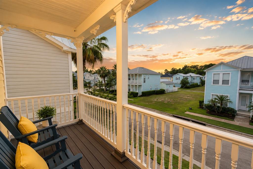 A balcony with two chairs overlooks a neighborhood street at sunset — 1549 FAIRVIEW CIRCLE, REUNION, FL