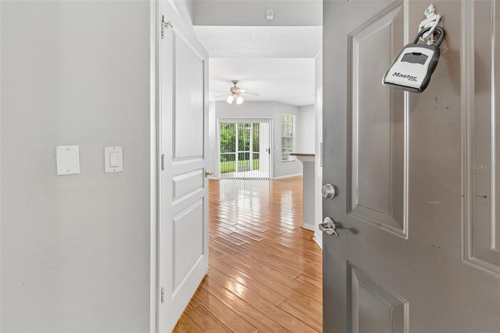 A view from an open doorway into a living area with hardwood floors and sliding doors — 5125 PALM SPRINGS BOULEVARD UNIT 15105, TAMPA, FL