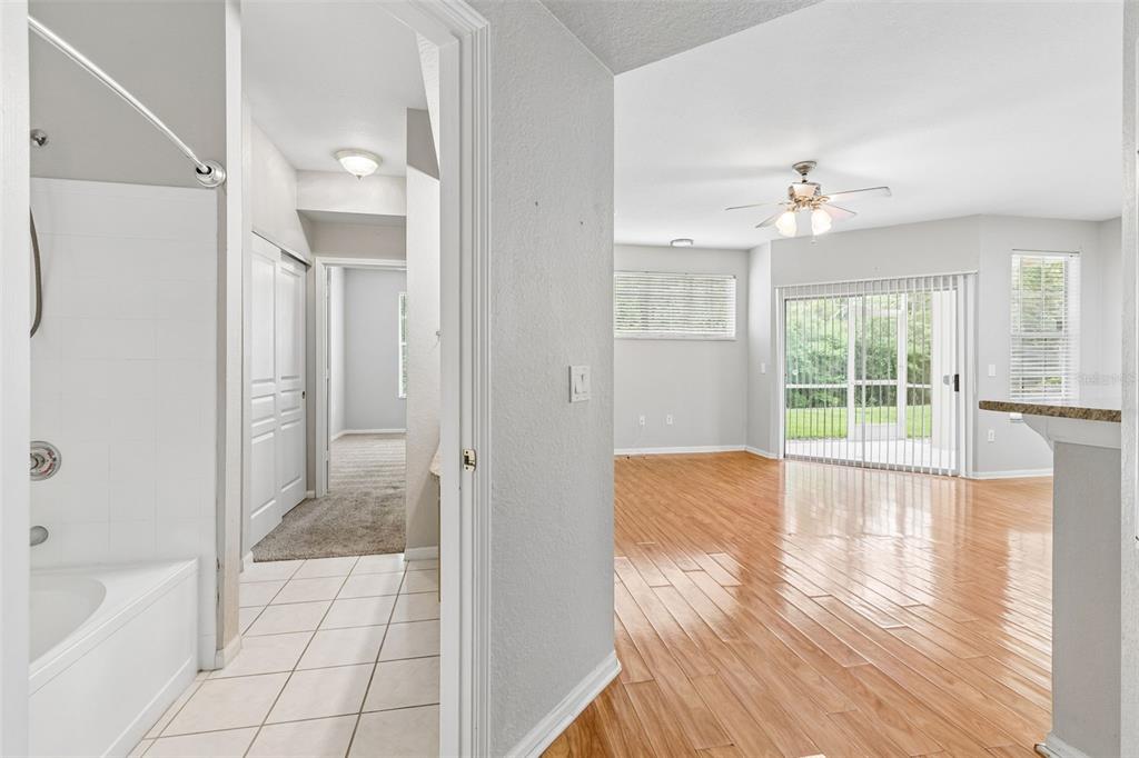 A view from a tiled bathroom looking into a living area with hardwood floors — 5125 PALM SPRINGS BOULEVARD UNIT 15105, TAMPA, FL