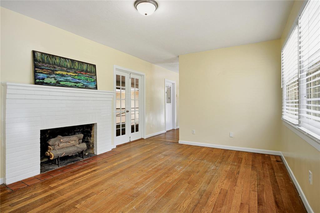 A living room with hardwood floors, a white brick fireplace, and French doors — 434 NW 25TH STREET, GAINESVILLE, FL