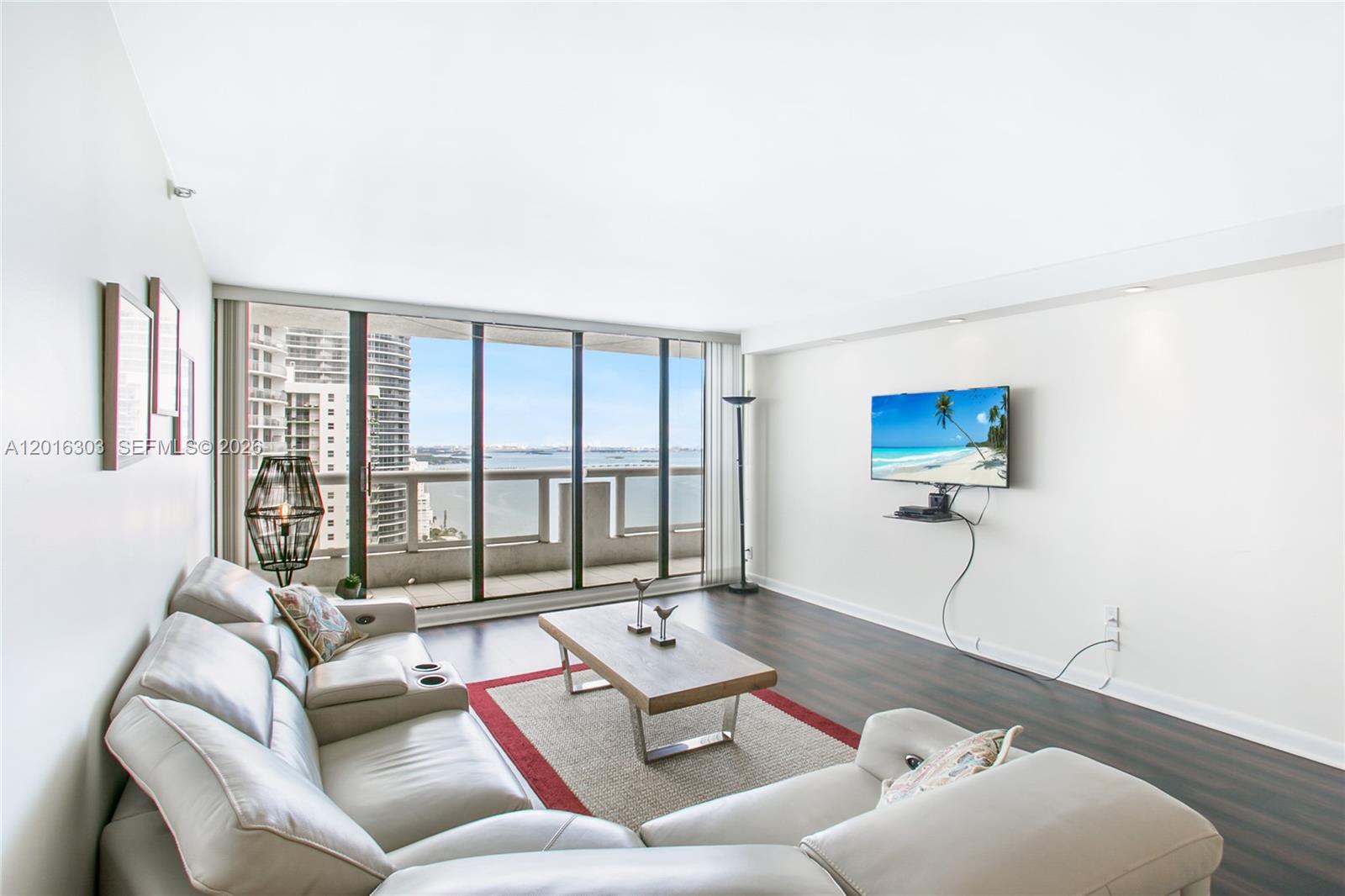 A living room features a light-colored sectional sofa, a coffee table, and a balcony view — 1717 N Bayshore Dr # 3751, Miami FL 33132, MIAMI, FL