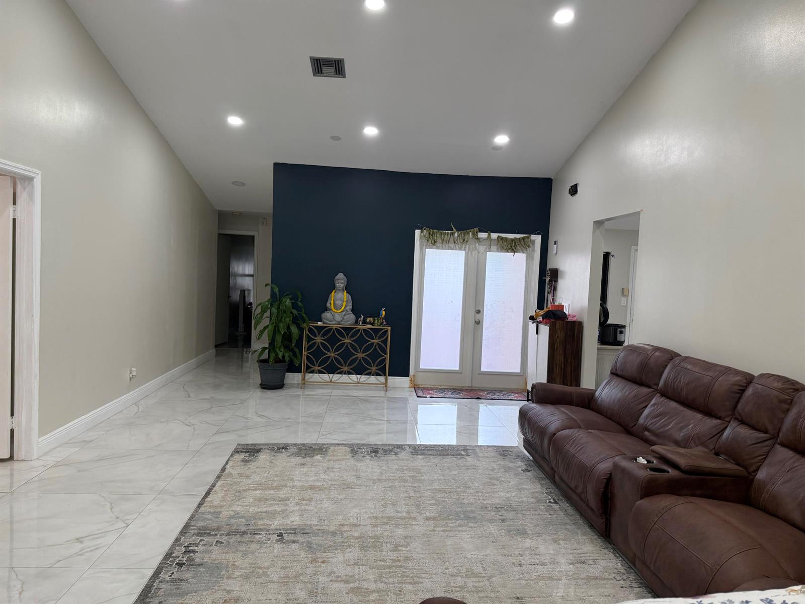 A living room features white walls, a dark blue accent wall, and light tile flooring — 6420 Via Tierra, Boca Raton FL 33433, BOCA RATON, FL