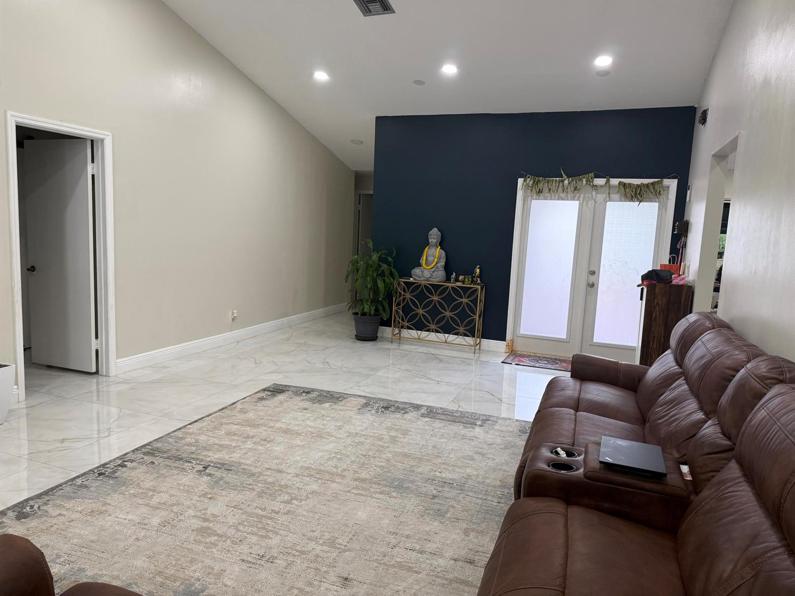 A living room features a dark blue accent wall, marble-look tile floors, and a brown sofa — 6420 Via Tierra, Boca Raton FL 33433, BOCA RATON, FL