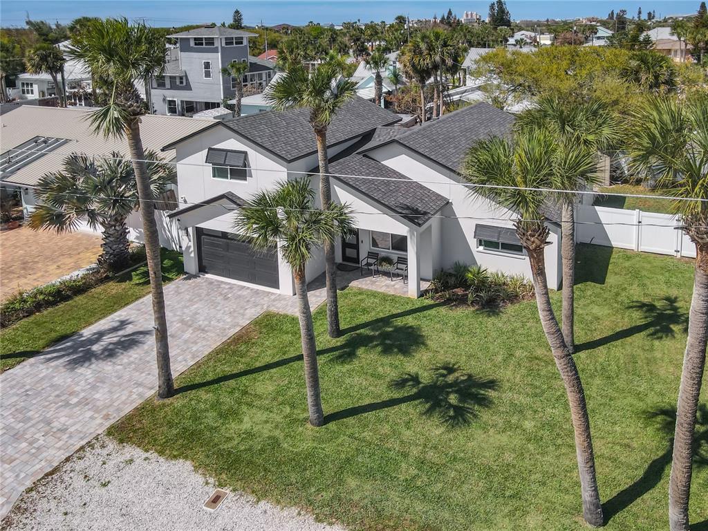 An aerial view of a white two-story house with a dark roof and palm trees — 214 CONDICT DRIVE, NEW SMYRNA BEACH, FL