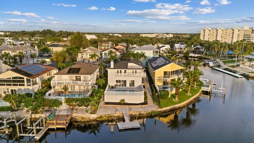 An aerial view shows waterfront houses with private docks and swimming pools along a canal — 6121 BAYSIDE DRIVE, NEW PORT RICHEY, FL