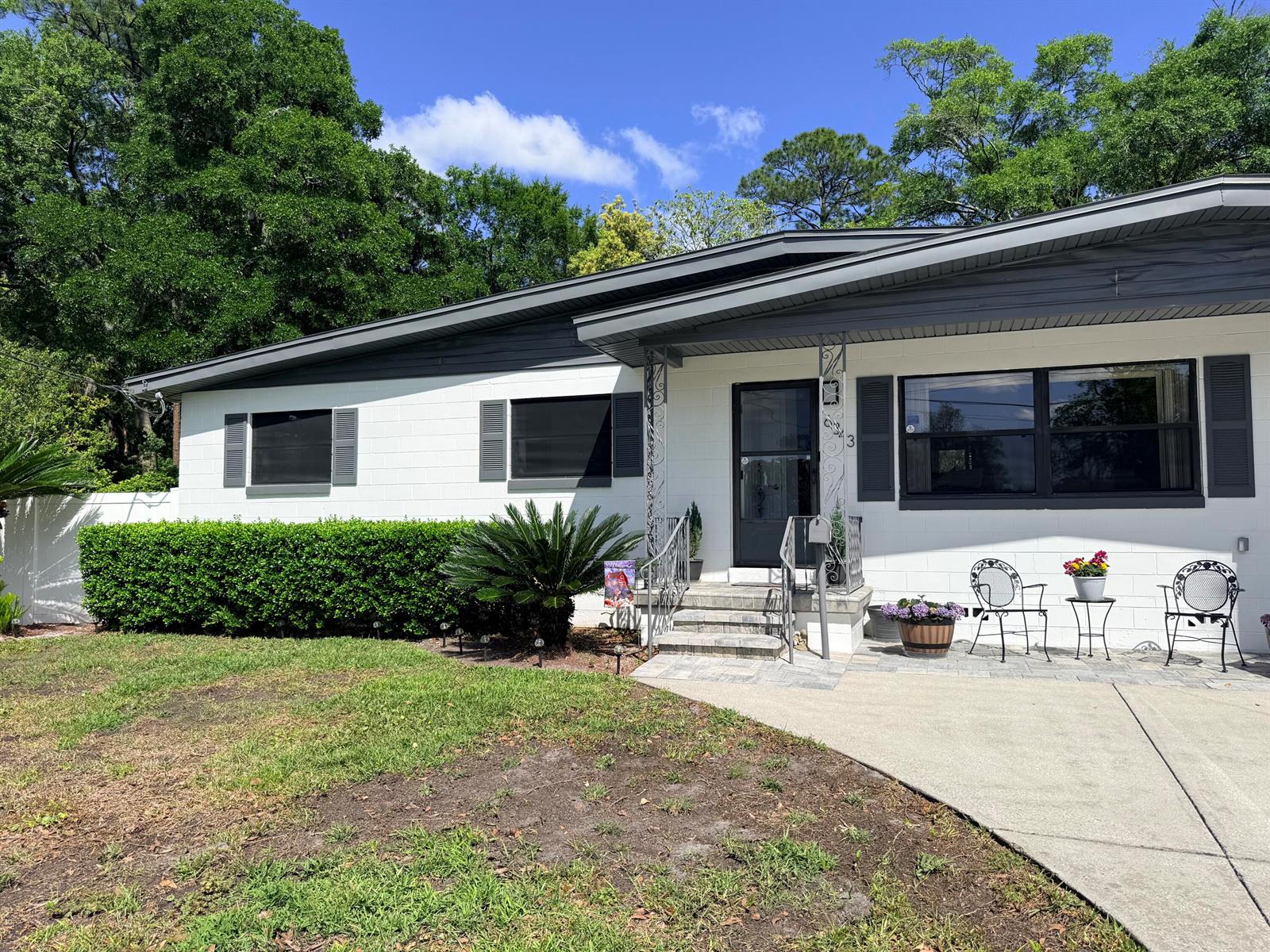 A white, single-story house with a gray roof, dark shutters, and a concrete driveway — 6343 Stetler Drive, Jacksonville FL 32216, JACKSONVILLE, FL