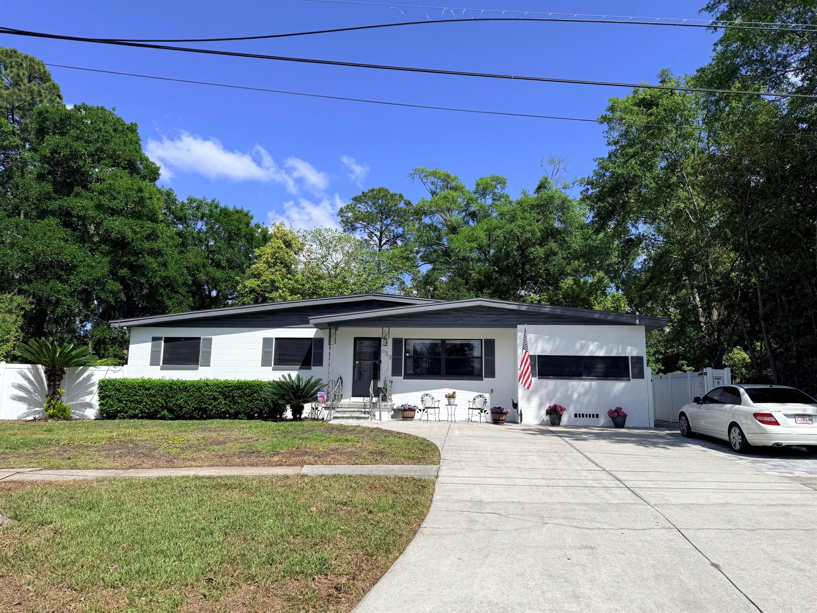 A white single-story house with a gray roof, dark shutters, and a concrete driveway — 6343 Stetler Drive, Jacksonville FL 32216, JACKSONVILLE, FL