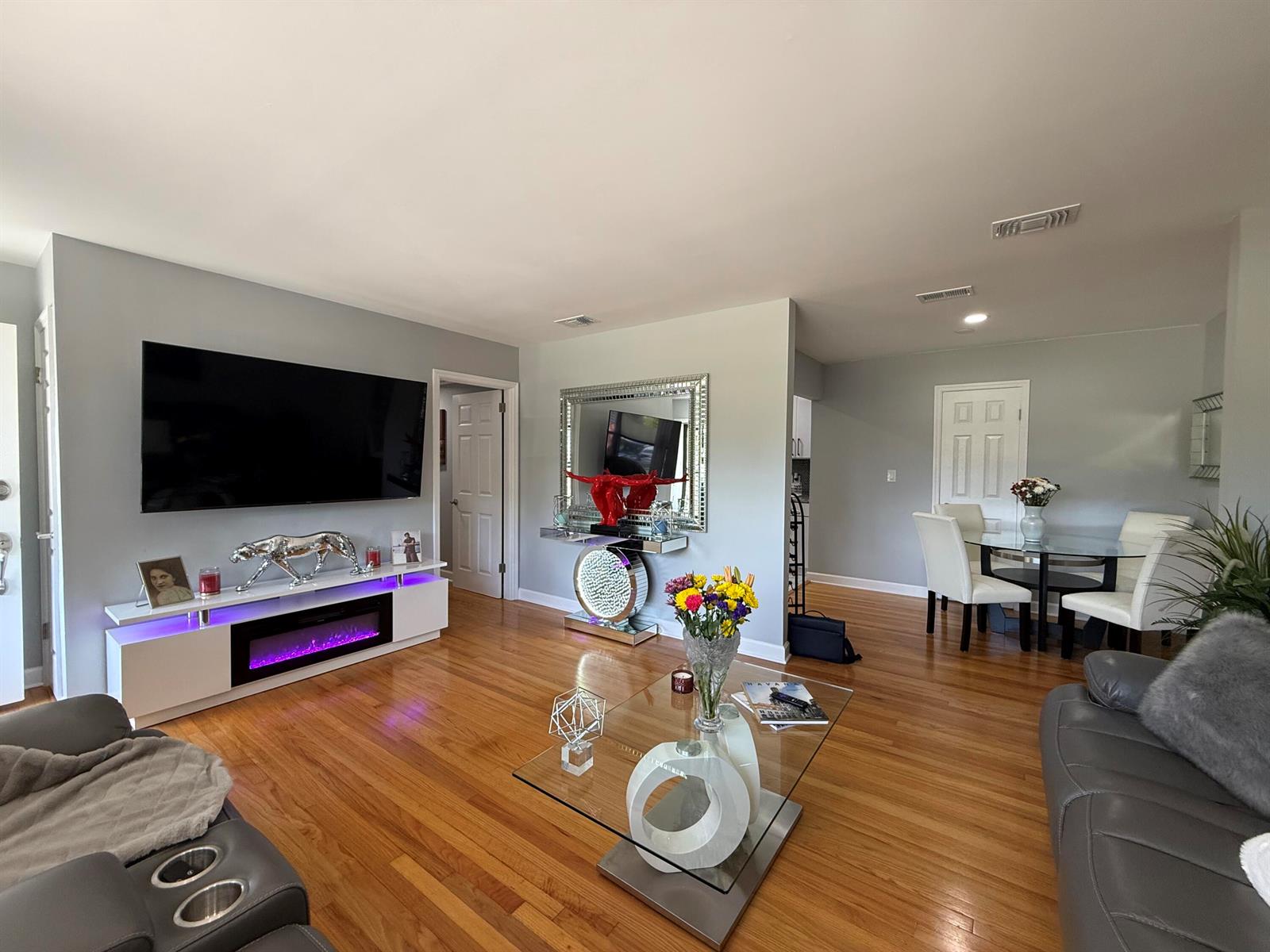 A living room with hardwood floors, a gray leather sofa, and a glass coffee table — 6343 Stetler Drive, Jacksonville FL 32216, JACKSONVILLE, FL