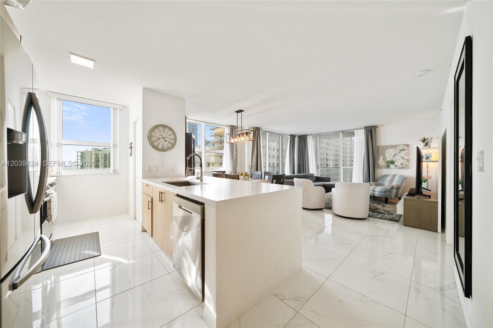 A modern open-concept kitchen and living area features white tile floors and large windows — 1155 Brickell Bay Dr # 2501, Miami FL 33131, MIAMI, FL