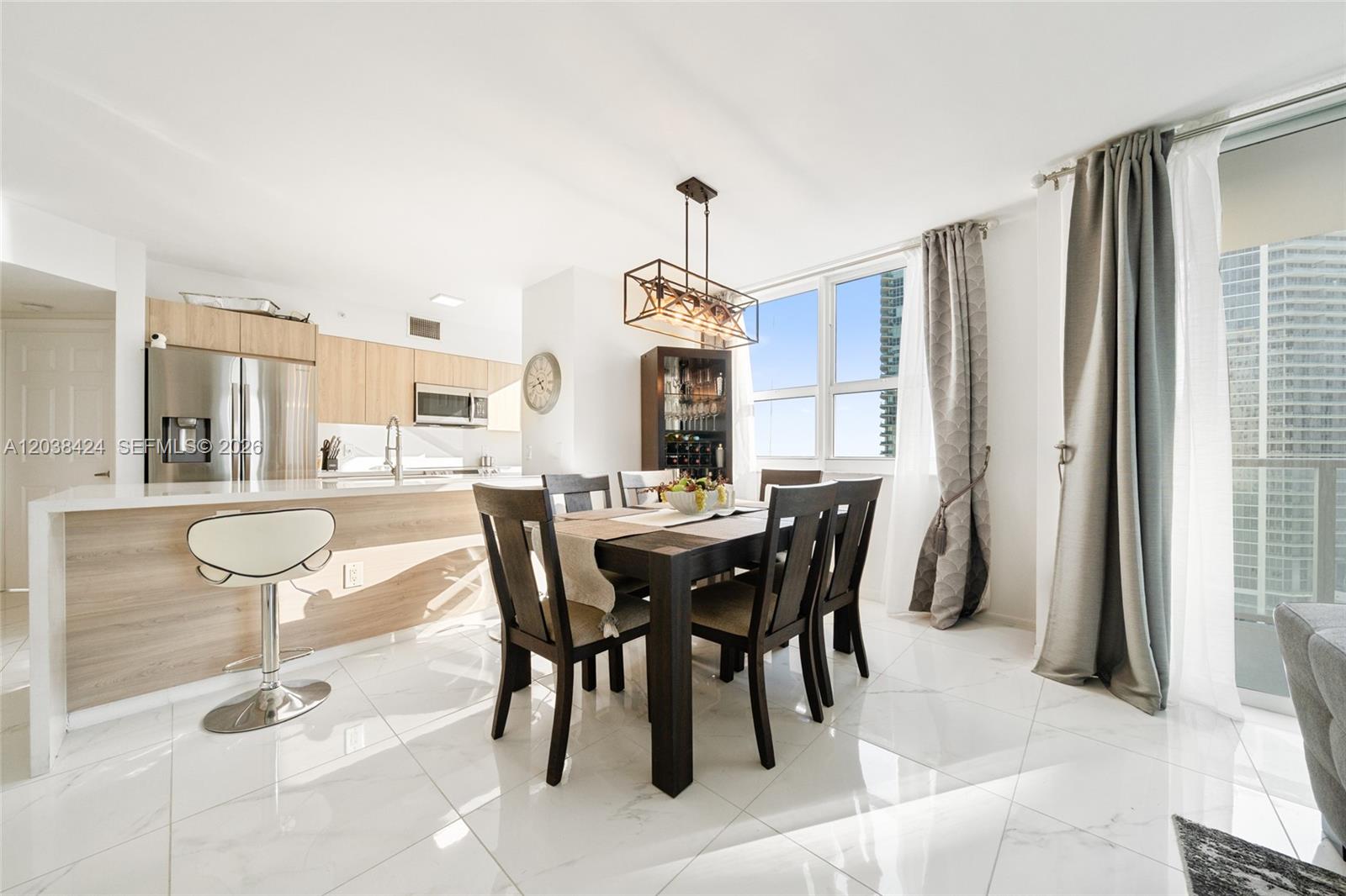 A dining area with a dark wood table and chairs sits beside an open kitchen — 1155 Brickell Bay Dr # 2501, Miami FL 33131, MIAMI, FL