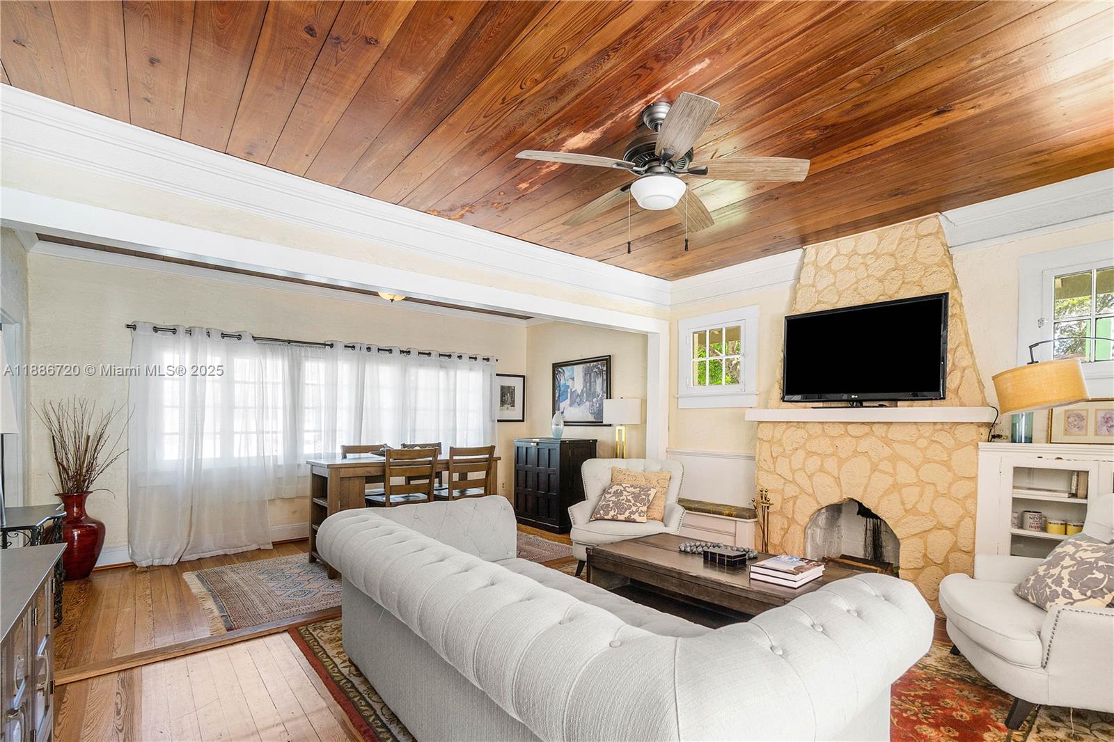 A living room features a stone fireplace, wood-paneled ceiling, and a tufted white sofa — 728 Newark St, West Palm Beach FL 33401, WEST PALM BEACH, FL