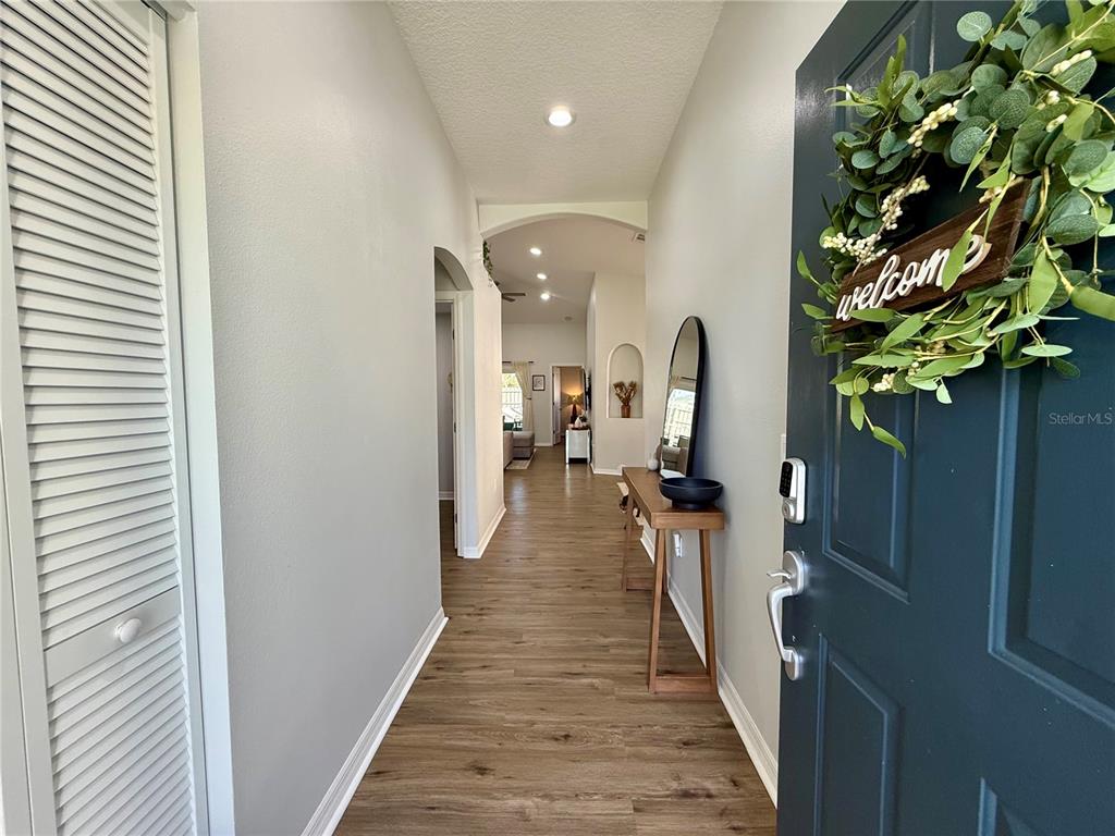 A view from an open front door into a hallway with wood-look flooring — 2532 VENTURA CIRCLE, WEST MELBOURNE, FL
