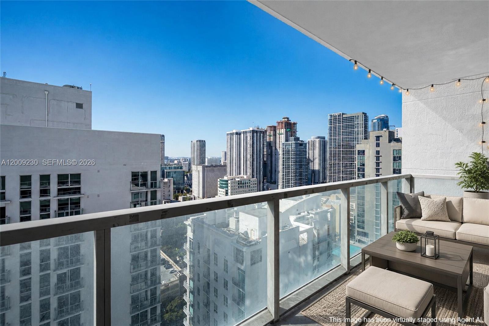 A balcony with outdoor furniture overlooks a dense city skyline under a clear blue sky — 253 NE 2nd St # 3104, Miami FL 33132, MIAMI, FL