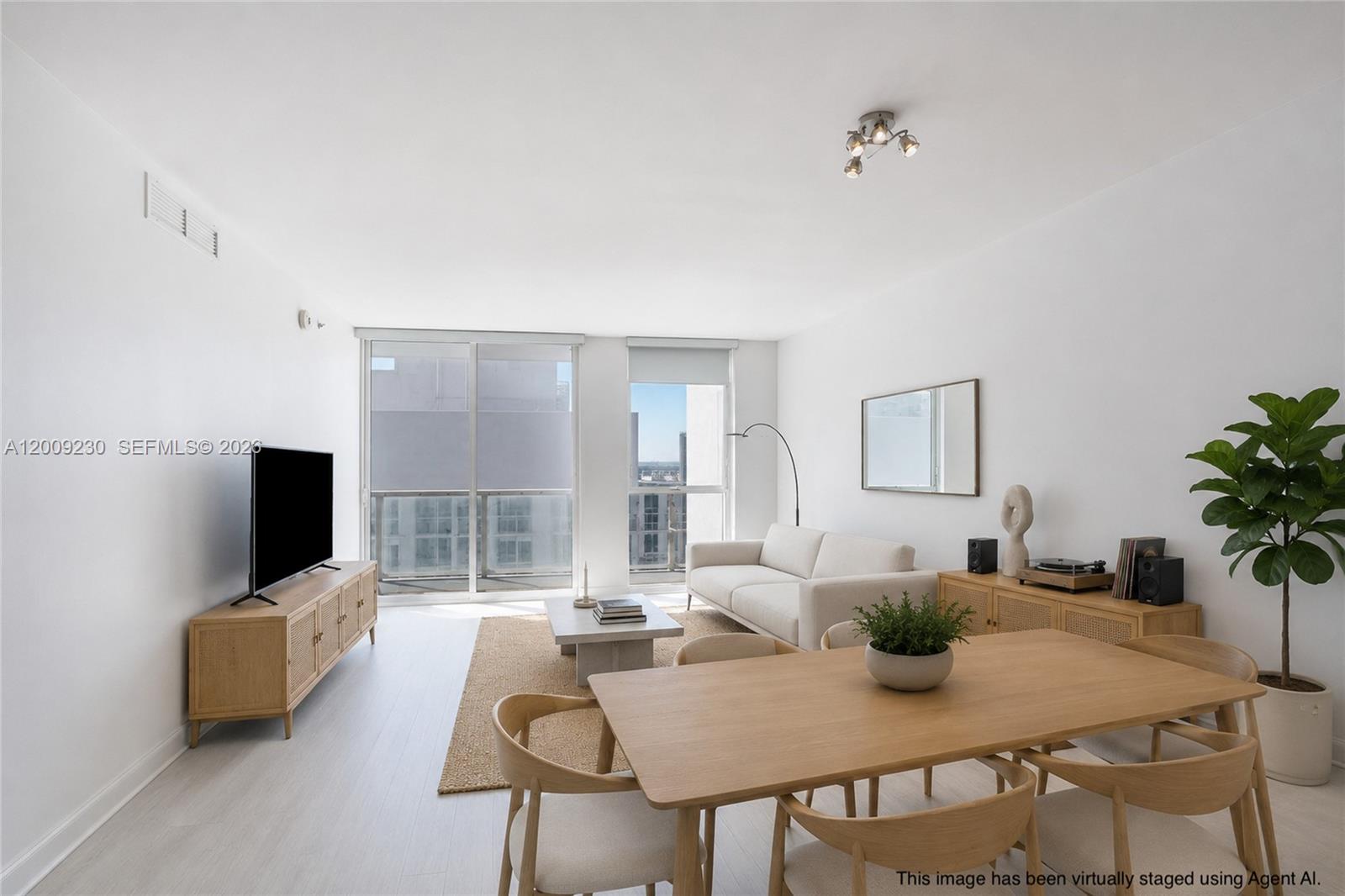 This virtually staged living and dining area features light wood furniture and a balcony view — 253 NE 2nd St # 3104, Miami FL 33132, MIAMI, FL