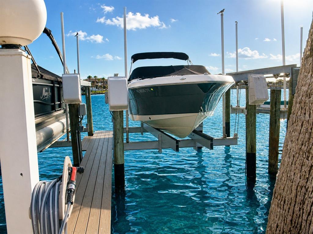 An aerial view shows a waterfront condominium complex with a pool and boat slips — 9825 HARRELL AVENUE UNIT 404, TREASURE ISLAND, FL