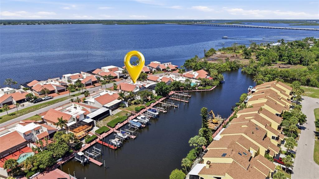 An aerial view shows waterfront townhomes with private boat slips along a canal — 25188 MARION AVENUE UNIT 10, PUNTA GORDA, FL