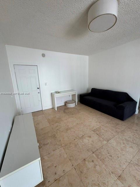 A living room features a dark sofa, a small white desk, and light-colored tile flooring — 934 Michigan Ave # 308, Miami Beach FL 33139, MIAMI BEACH, FL