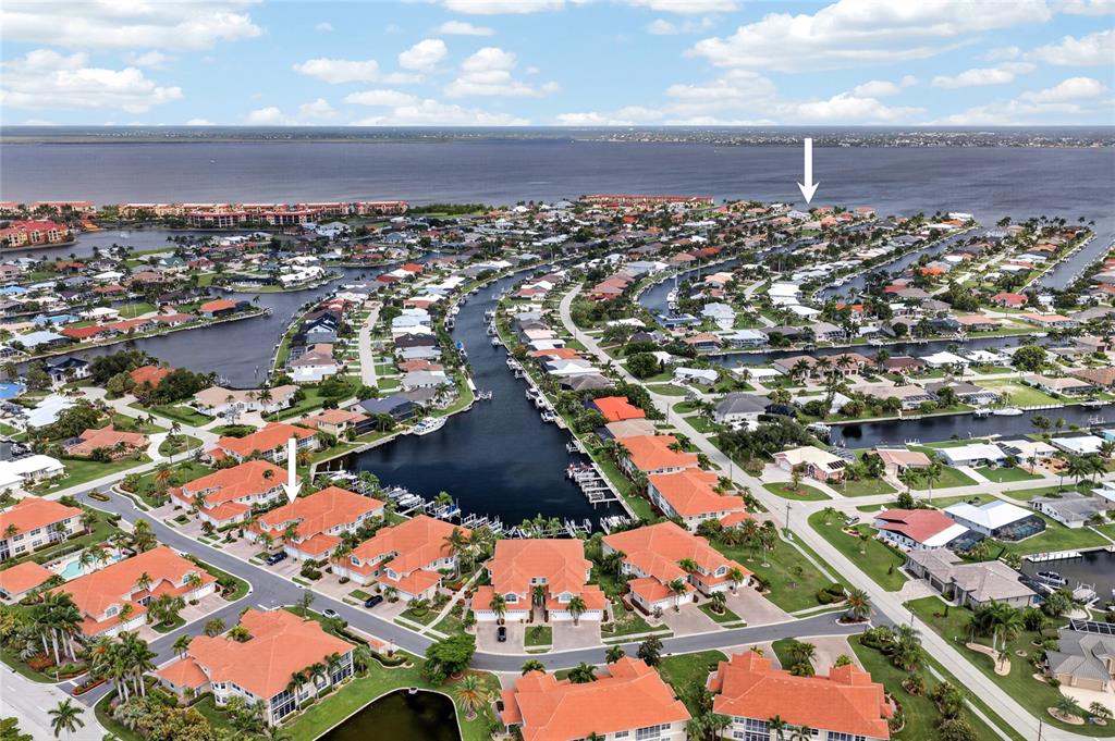 An aerial view shows a residential waterfront community with canals and numerous tile-roofed homes — 2590 TARPON COVE DRIVE UNIT 821, PUNTA GORDA, FL