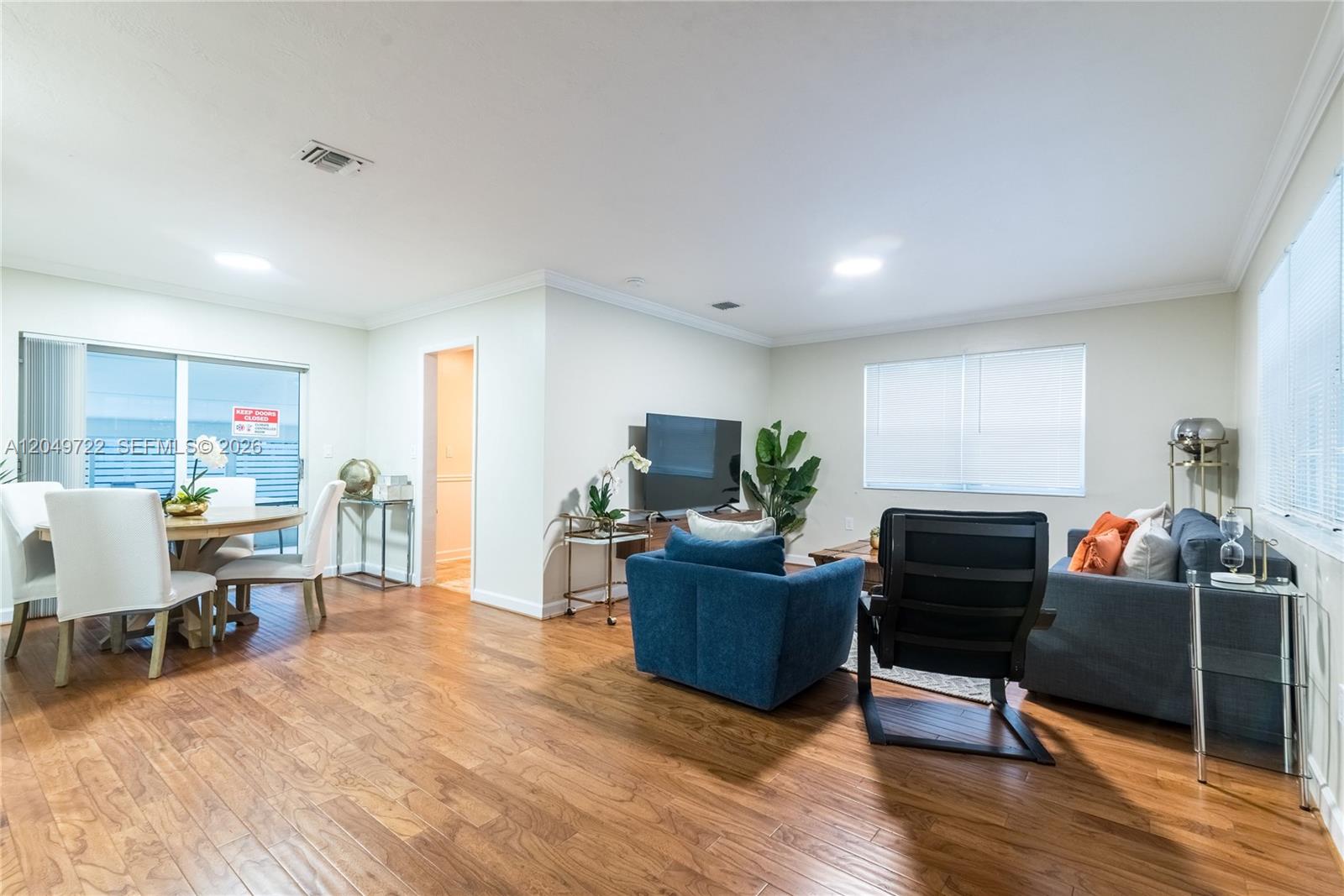 A living and dining area features hardwood floors, a blue armchair, and a grey sofa — 2270 Havana Dr, Miramar FL 33023, MIRAMAR, FL