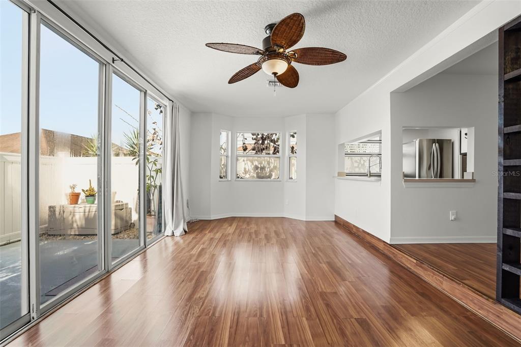 An empty room with wood-look flooring, a ceiling fan, and sliding glass doors to a patio — 245 MANGO DRIVE, DAVENPORT, FL