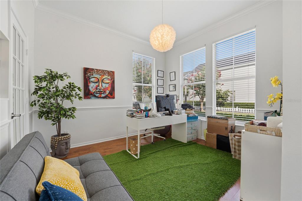 A home office features a green rug, a white desk, and a grey sofa — 181 LONGVIEW AVE, KISSIMMEE, FL