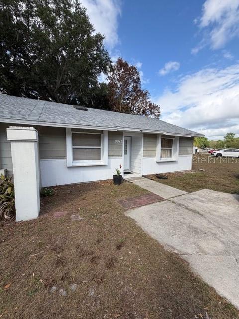 A single-story house exterior features light-colored siding, a concrete walkway, and a small front yard — 9943 BURL WAY, ORLANDO, FL